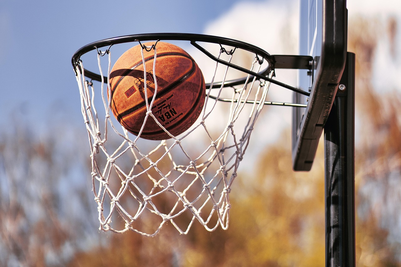 An adjustable basketball hoop set up on a driveway